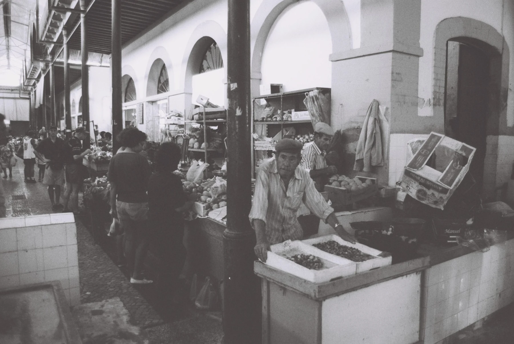 Antigo mercado de Tavira: bancas de produtos e pessoas no interior do mercado
